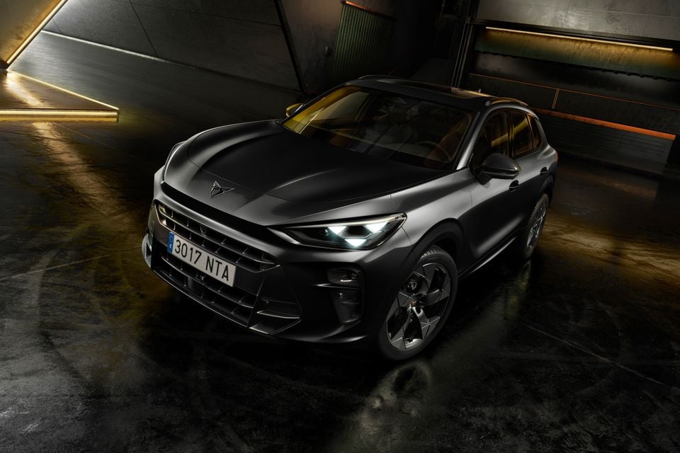 A dark grey Cupra Terramar VZ Tribe Edition SUV seen from a high front three-quarter angle in a dimly lit studio setting.