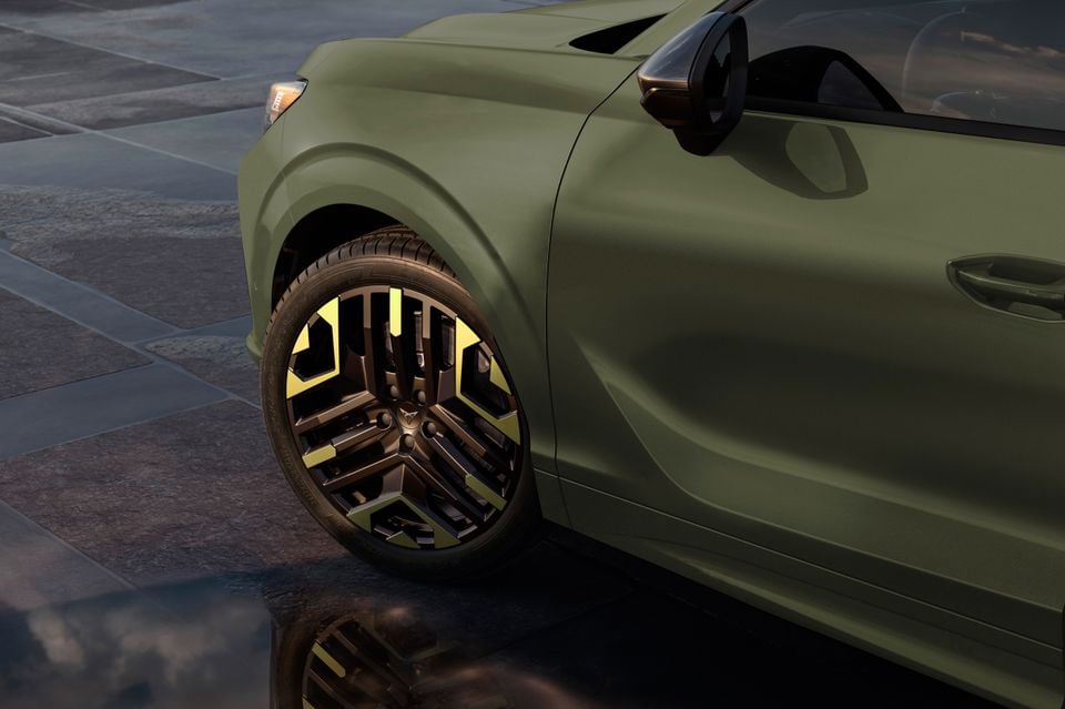 Close-up of the rear quarter panel and alloy wheel on a Cupra Terramar VZ Tribe Edition in matte olive green, featuring distinctive two-tone black and yellow-green alloy wheels