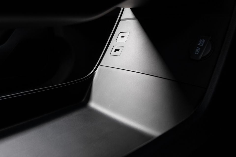Close-up of USB-C ports and a 12V power socket inside the centre console of a car