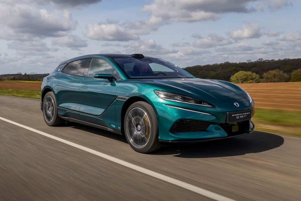A teal Denza Z9 GT shooting brake driving along a country road, seen from the front quarter
