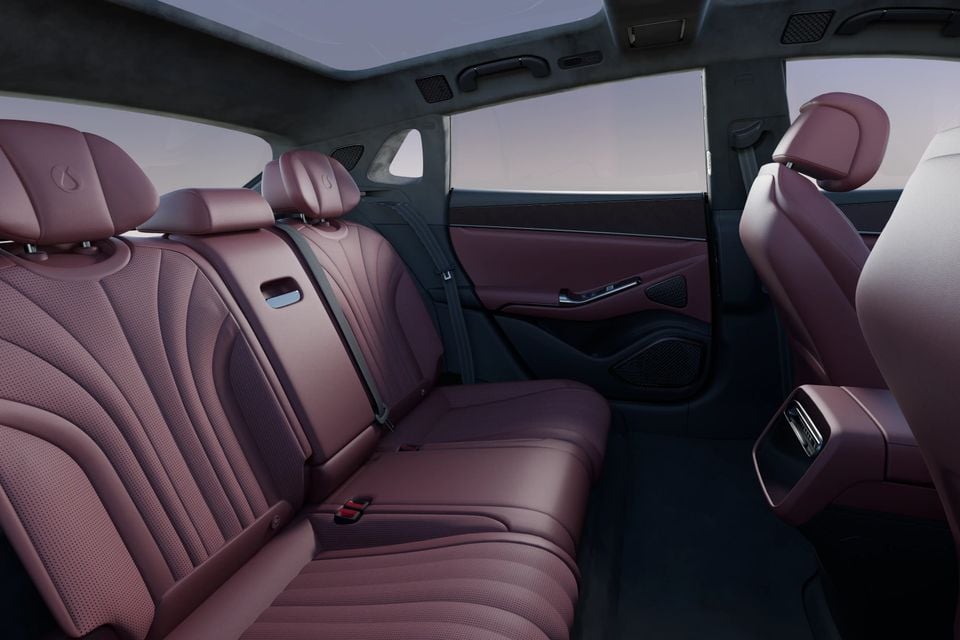 Rear seats of the Denza Z9 GT trimmed in burgundy perforated leather, with a large glass roof and a rear centre console with air vents