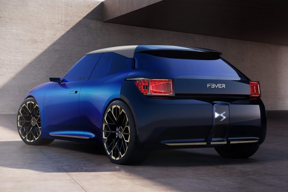 Hatchback conceito DS F3VER azul visto de três quartos traseiro, estacionado sob uma saliência de concreto com grandes rodas com detalhes em bronze