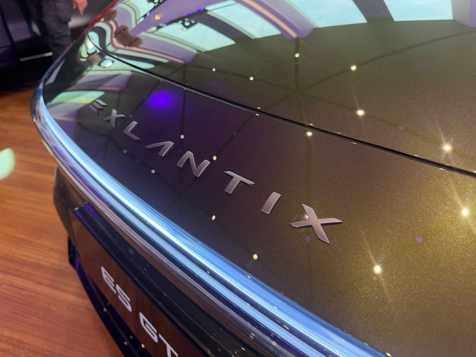 Close-up of the Exlantix lettering and illuminated front light bar on the green ES GT, with part of its ES GT plate visible.