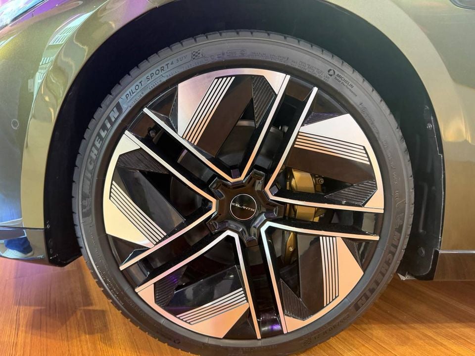 Close-up of the green Exlantix ES GT’s two-tone alloy wheel, Michelin tyre and gold-coloured brake caliper.