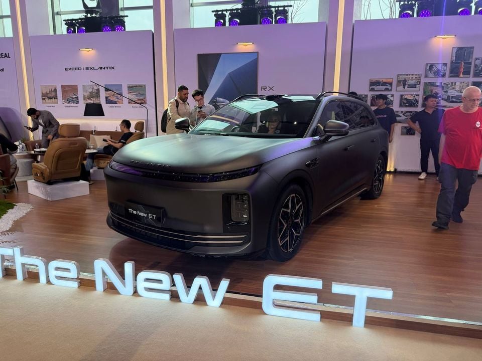 Wide front three-quarter view of the silver Exlantix new ET SUV and its New ET display sign at the Shanghai event.