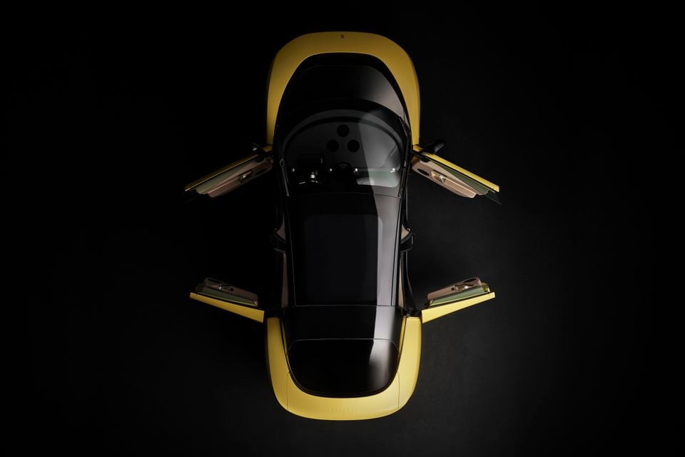 A yellow Ferrari Luce seen from directly above with all four doors open, shot against a dark studio background