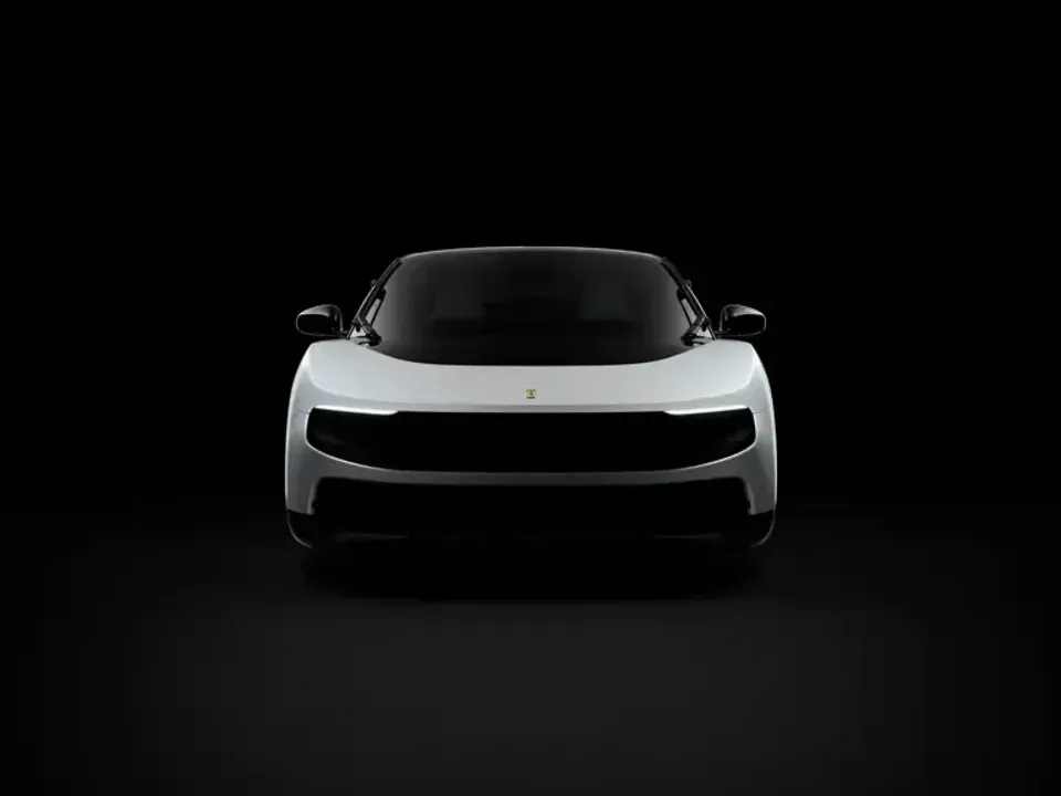 A white Ferrari Luce seen from the front against a dark background, showing its sleek modern design and illuminated headlights.