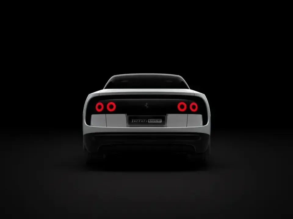 A white Ferrari Luce sports car seen from directly behind, with quad round red tail lights illuminated against a dark studio background