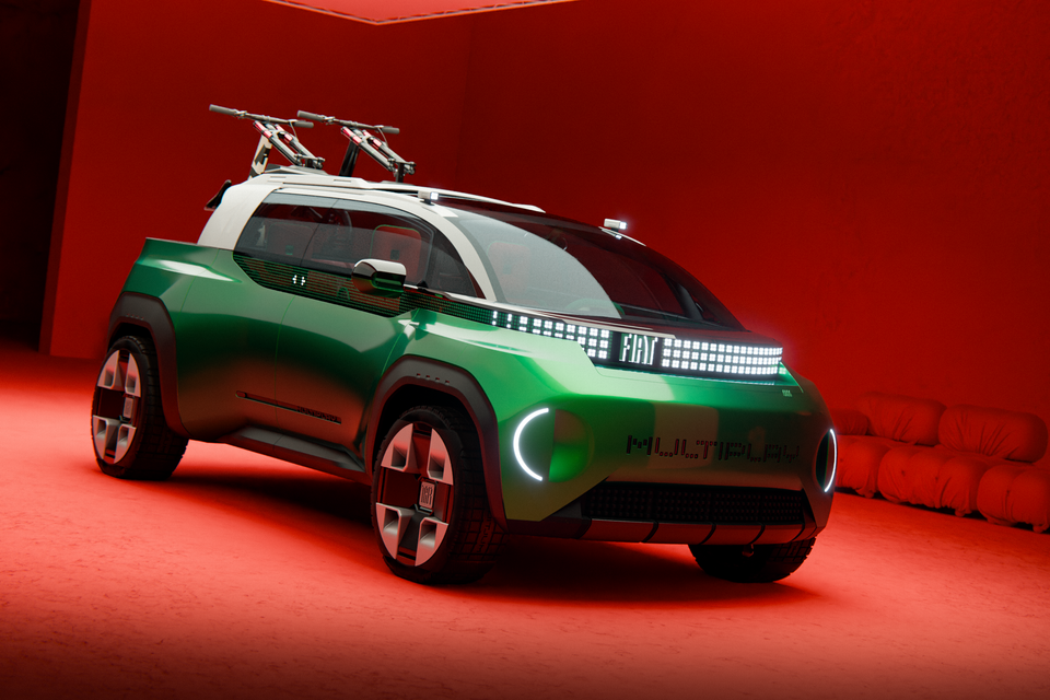 A green Fiat Multipla concept with white roof and roof-mounted bike racks, shown from the front quarter in a red studio