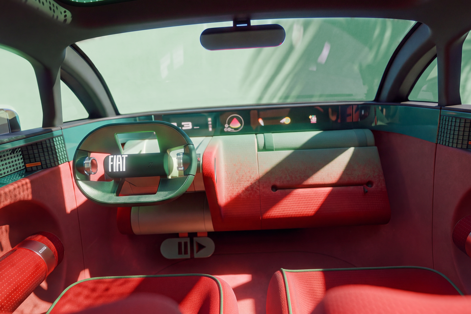 Cabin of the Fiat Multi Play concept with an oval steering wheel, wide digital display, play and pause style controls and red fabric seats
