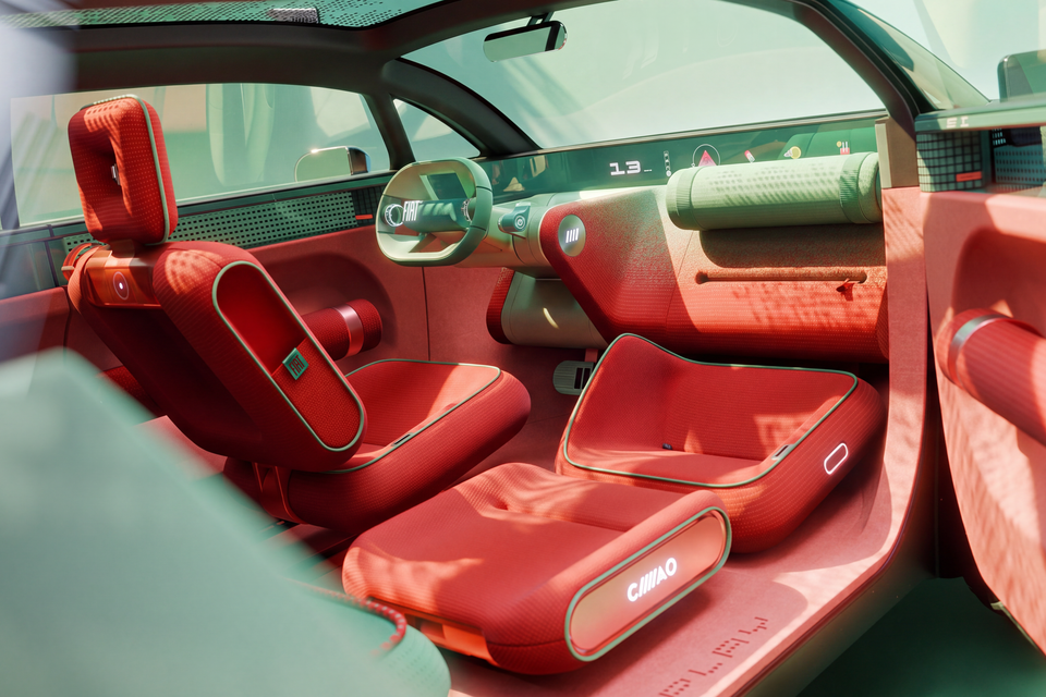 Red fabric interior of the Fiat Multi Play concept with a squared-off steering wheel, wide dashboard display and modular front seats