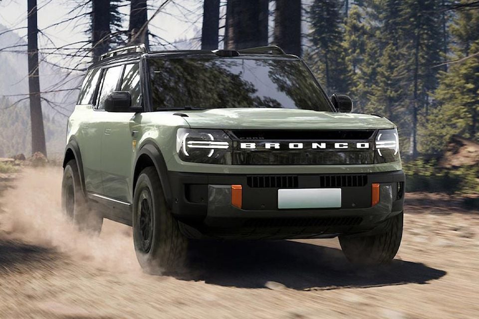 A green Ford Bronco SUV driving on a dusty off-road trail through a forest, seen from the front