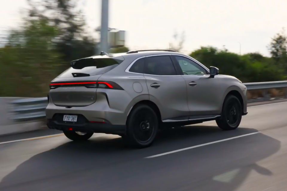 A silver Forthing electric SUV seen from the rear three-quarter angle while driving on a road in Australia
