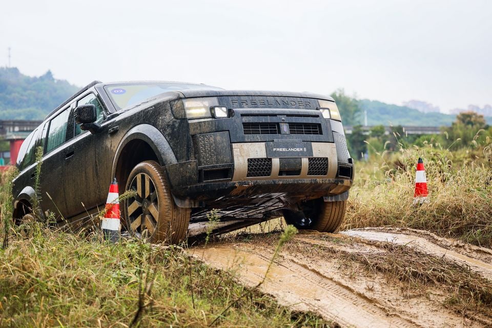 Dark Freelander 8 atravessando terreno irregular com articulação visível das rodas.