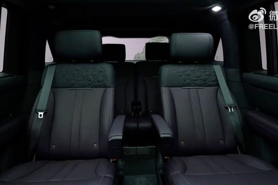 The rear seat interior of the Freelander 8 SUV, showing two quilted black leather captain's chairs with integrated armrests and headrest-mounted screens
