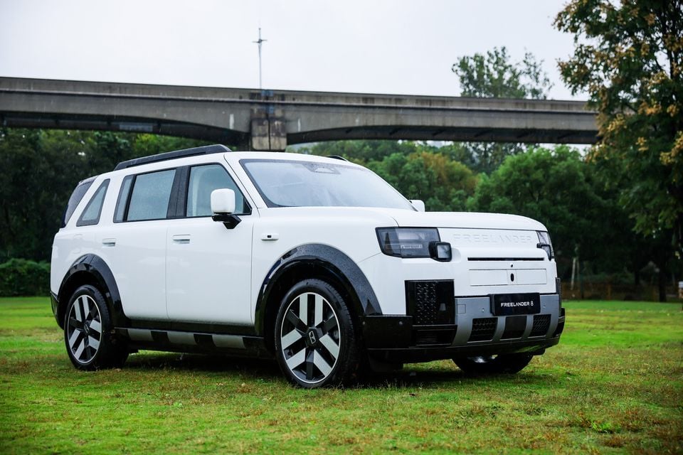 Freelander 8 branco estacionado na grama, vista frontal de três quartos