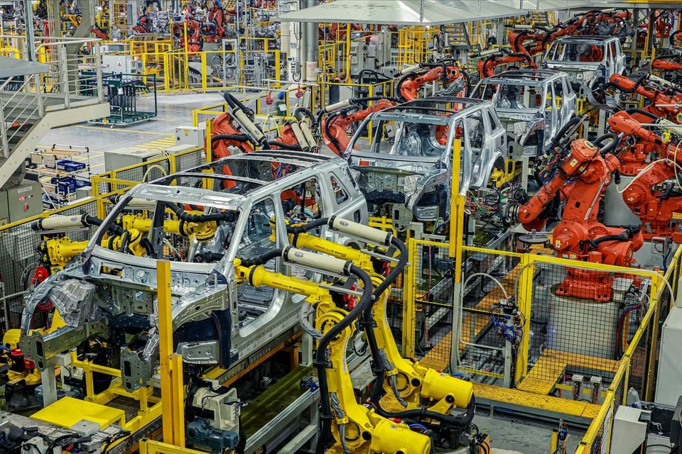 Carrocerias de veículos cercadas por robôs industriais na oficina de soldagem da fábrica de Changshu