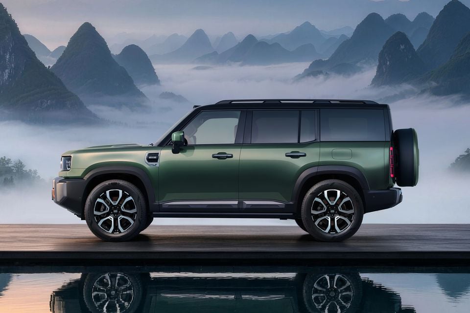 A green Geely Galaxy Cruiser SUV shown from the side, with a spare wheel mounted on the rear and a misty mountain backdrop