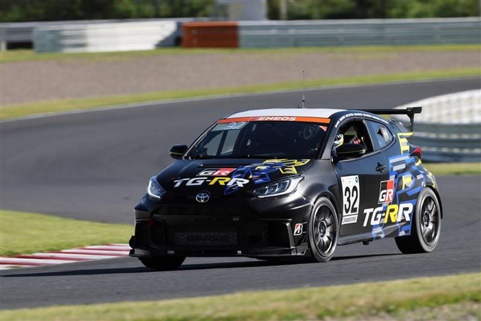 Um carro de corrida Toyota GR Yaris número 32 com pintura GR TG-RR competindo em um circuito