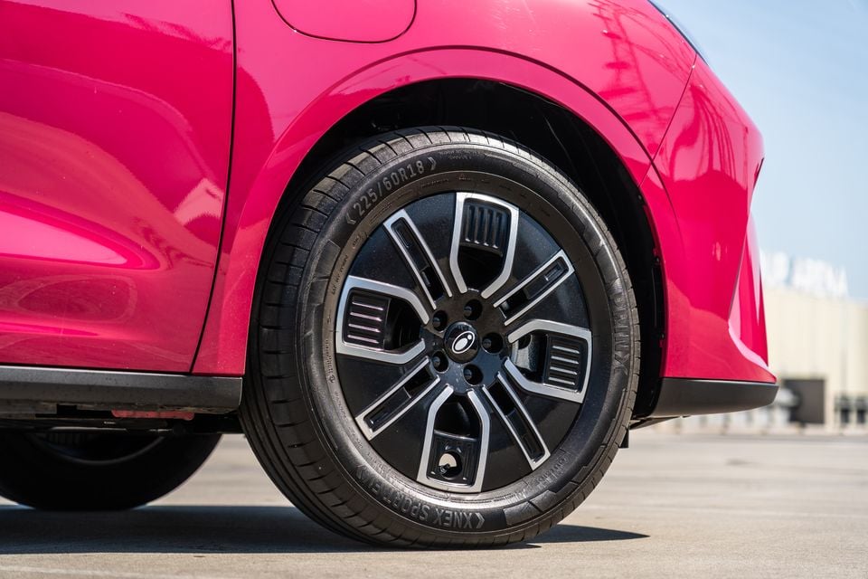 Close-up of the front wheel of a pink GWM Ora 5, showing a black and silver 18-inch alloy wheel with Linglong tyre