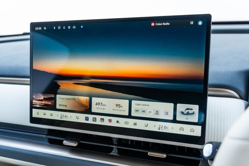 Touchscreen infotainment display in the GWM Ora 5 showing driving range, energy regeneration, light controls and climate settings
