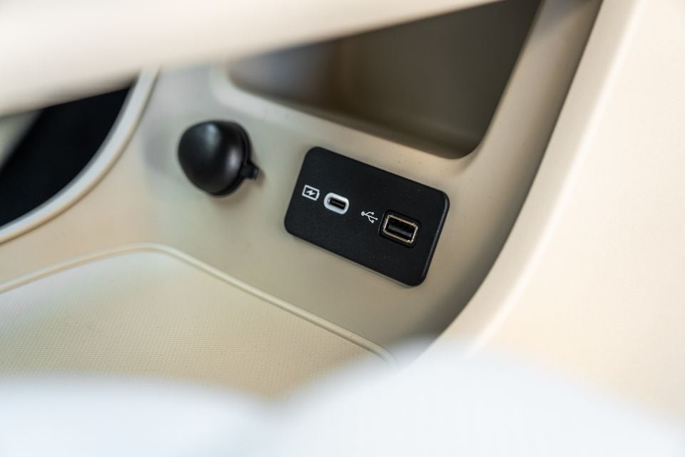 USB-C and USB-A charging ports beside a 12-volt socket in the cream-coloured centre console of a GWM Ora 5