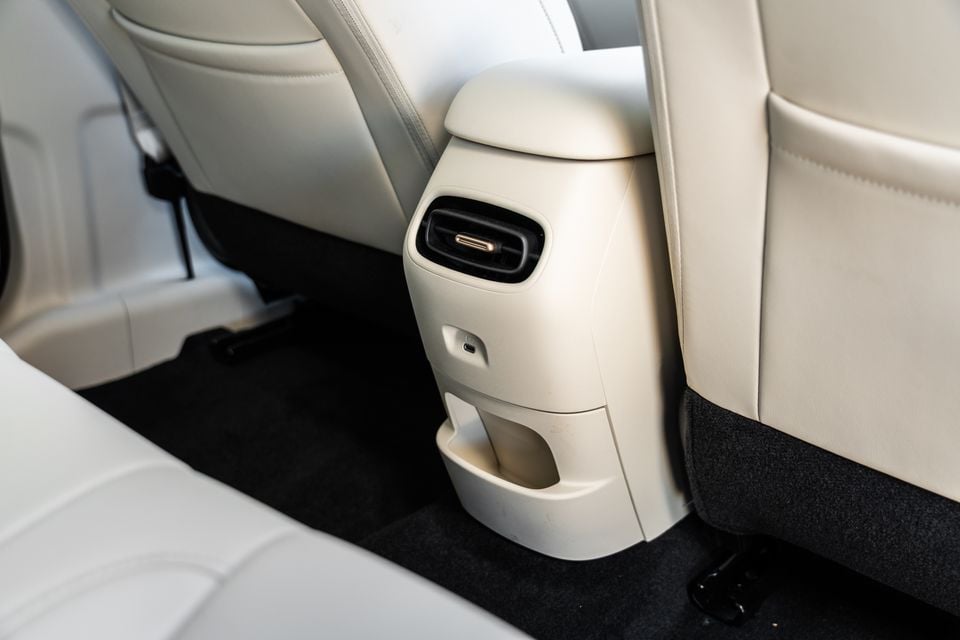 Rear of the centre console in a GWM Ora 5 with cream trim, showing a rear air vent, USB-C port and storage cubby between the front seats