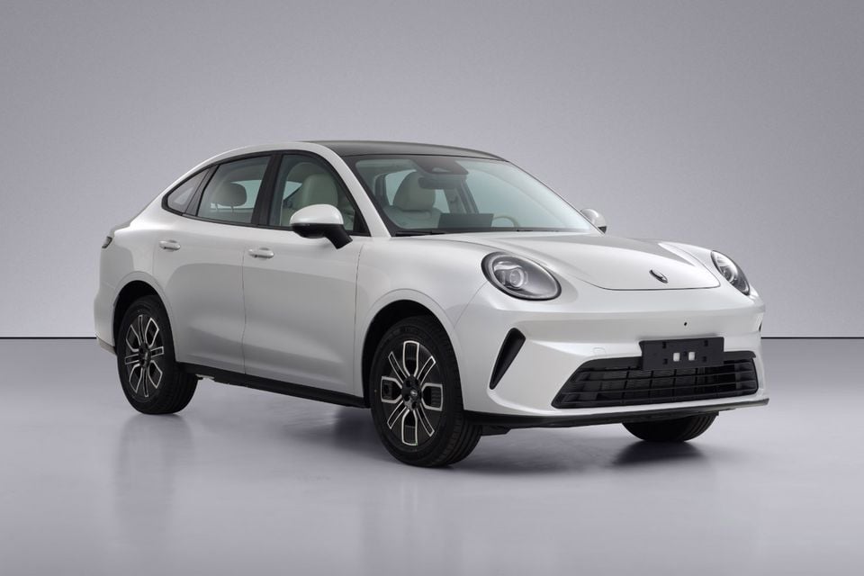 A white GWM ORA 5 sedan photographed from the front-side angle in a studio setting