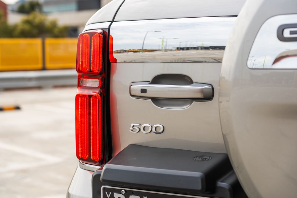 Close-up of the rear quarter panel of a GWM Tank 500, showing the tail light, door handle, and '500' badge