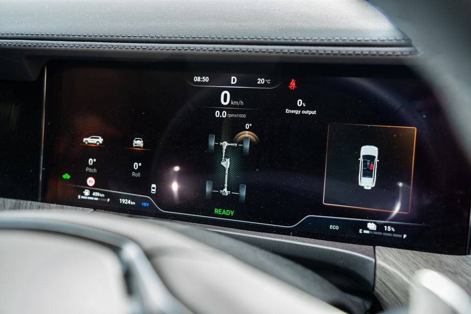 The digital instrument cluster of a GWM Tank 500 PHEV showing speed, pitch and roll readouts, energy output, drivetrain animation, and a bird's-eye vehicle view on a dark display.