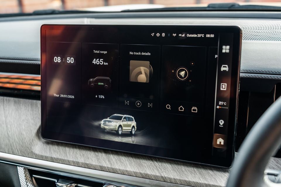 The infotainment touchscreen of a GWM Tank 500 Hi4-T PHEV showing the home screen with a total range of 465km, battery charge at 15%, time, date, and a 3D render of the SUV