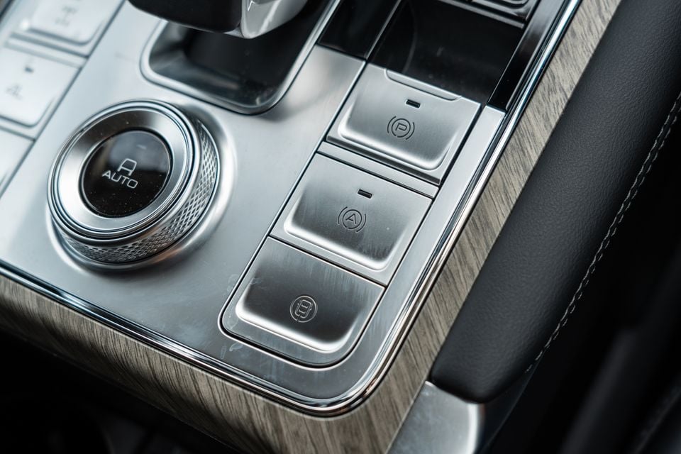 Close-up of the centre console controls in a GWM Tank 500 PHEV, showing the park button, auto hold, and electronic parking brake buttons alongside a rotary drive mode selector