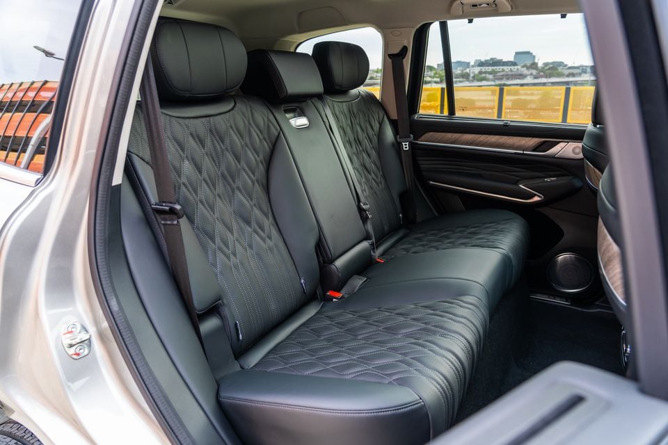 Rear passenger seat of a GWM Tank 500 SUV, showing quilted black leather upholstery with diamond stitching, wood trim accents, and seatbelts