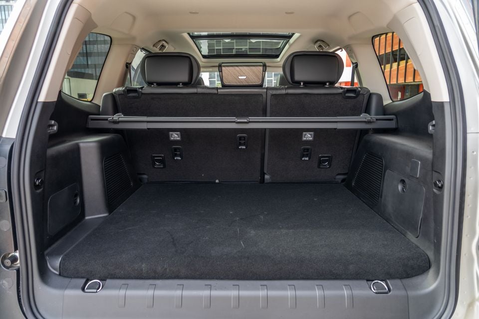 The empty boot of a GWM Tank 500 SUV, viewed from the rear, showing a carpeted load floor, cargo barrier rail, ISOFIX and top-tether anchor points on the rear seatbacks, and a sunroof visible above.