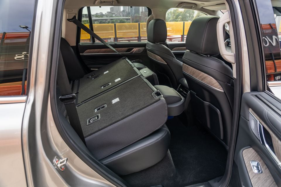 The third-row seat folded flat inside the GWM Tank 500 PHEV SUV, showing the rear cabin with leather second-row seats and wood trim