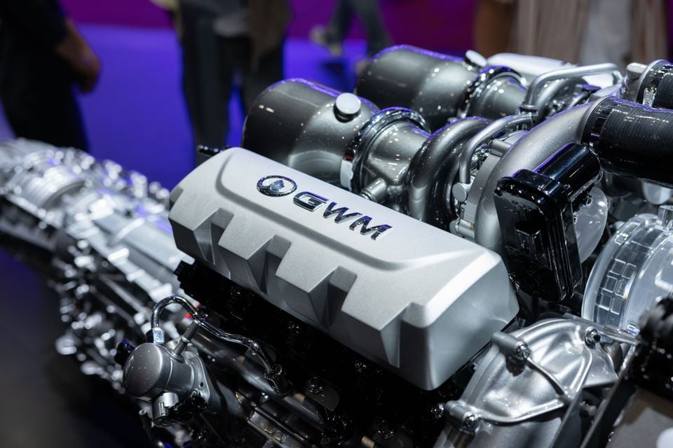 A close-up of a GWM V8 engine on display, showing the turbochargers and valve cover with the GWM badge
