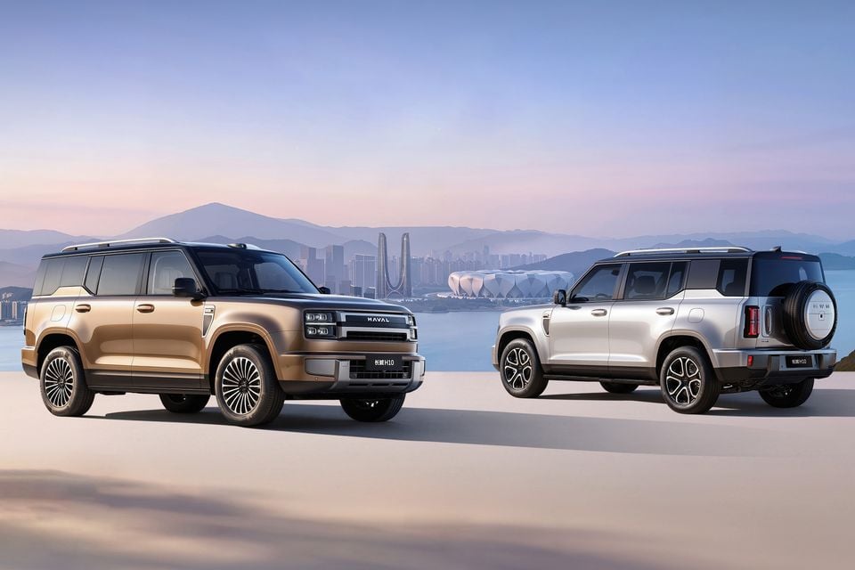 Two Haval H10 SUVs shown together — a gold one from the front and a silver one from the rear — against a scenic city skyline backdrop
