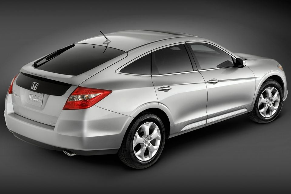 Um Honda Accord Crosstour prateado visto do ângulo traseiro de três quartos em um ambiente de estúdio