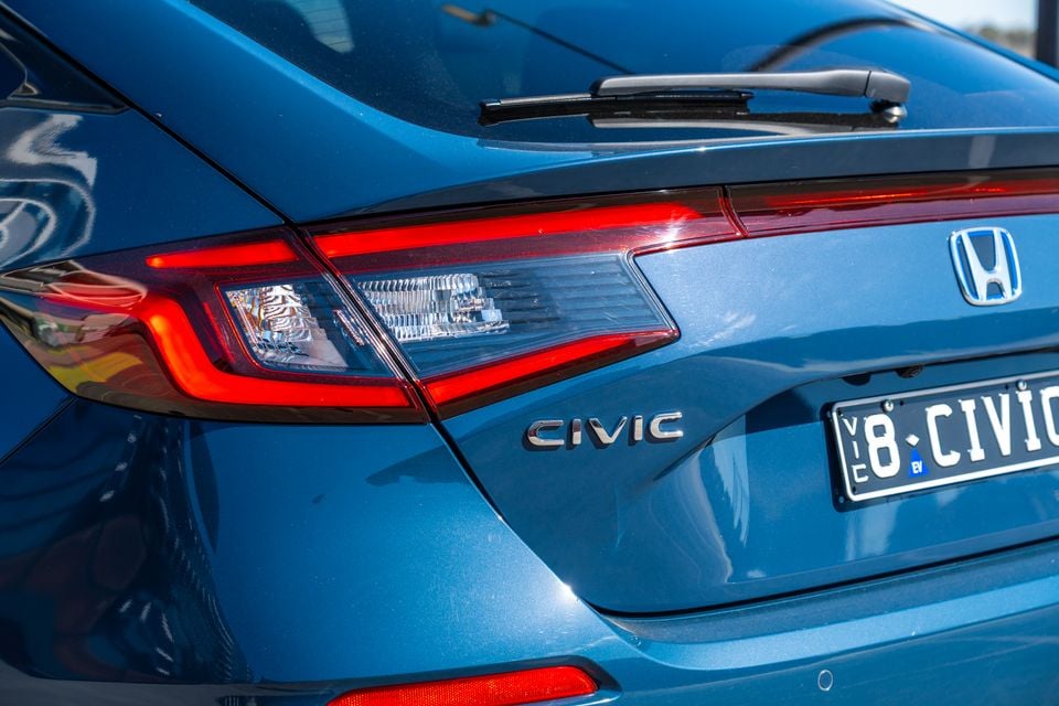 Close-up of the rear of a blue Honda Civic hatchback, showing the tail light, Civic badge, Honda logo, and a Victorian number plate.