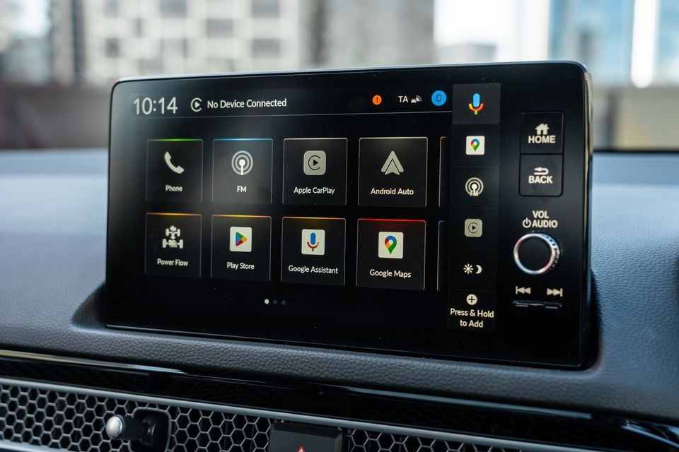 The touchscreen infotainment system in a Honda Civic e:HEV showing Apple CarPlay, Android Auto, Google Maps, Google Assistant, Play Store and Power Flow app icons