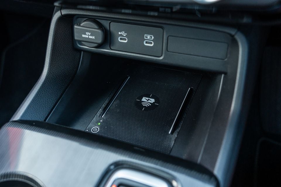 Wireless charging pad and USB-C ports in the centre console of a Honda Civic e:HEV, with a 12V power outlet nearby