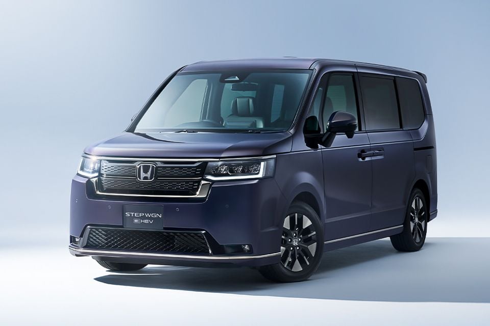 A dark purple Honda Step WGN e:HEV minivan photographed from the front quarter angle in a studio