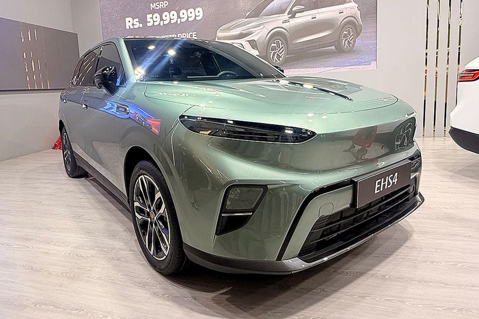 A green Hongqi EHS4 electric SUV displayed at a motor show, seen from the front-side angle