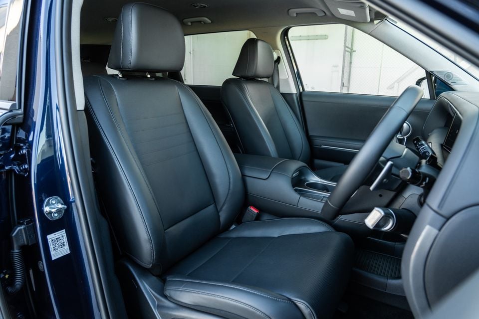 Interior view of a Hyundai Palisade Hybrid Elite showing black leather front seats, centre console, and steering wheel
