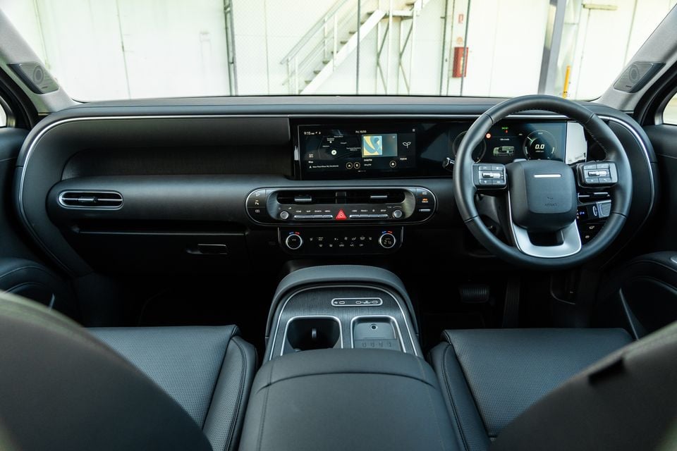 Interior view of a Hyundai Palisade Hybrid showing the dashboard, central infotainment screen, steering wheel, centre console and front seats from a right-hand drive perspective