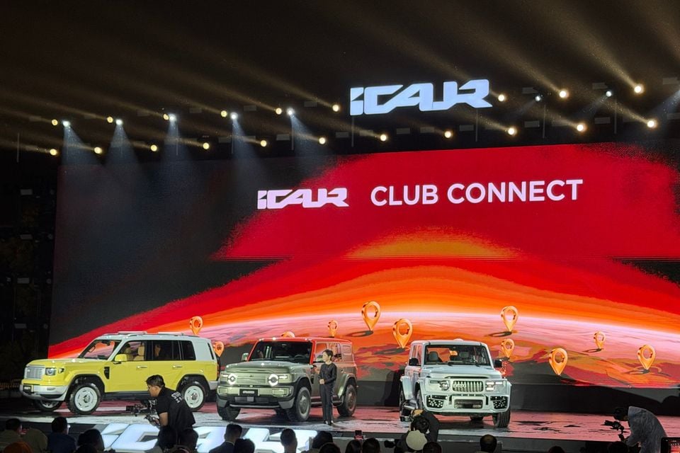 Three iCaur SUVs displayed on a stage beneath iCaur branding at an event in China
