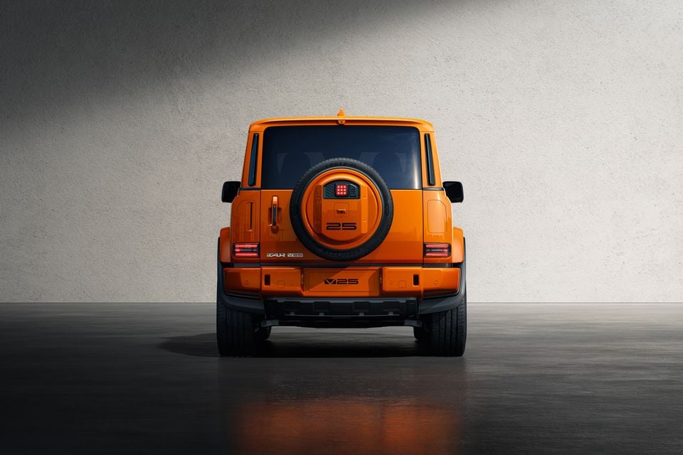 Rear view of an orange ICAUR V25 SUV with a spare wheel mounted on the tailgate, seen in a studio setting