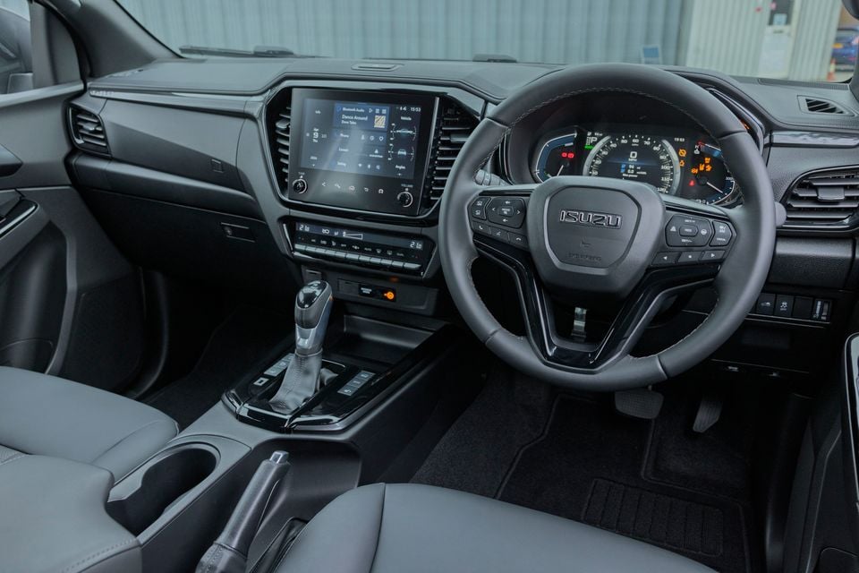 The interior of an Isuzu D-Max EV, showing the steering wheel, digital instrument cluster, and infotainment touchscreen.