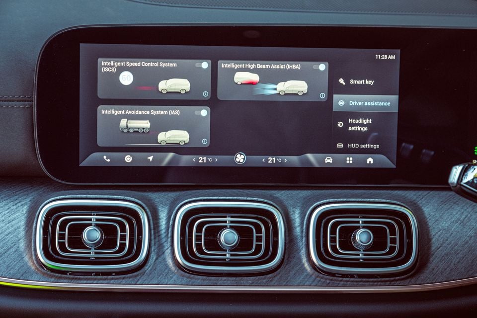 The Jaecoo J8's infotainment screen showing driver assistance settings including Intelligent Speed Control System, Intelligent High Beam Assist, and Intelligent Avoidance System, with three air vents visible below