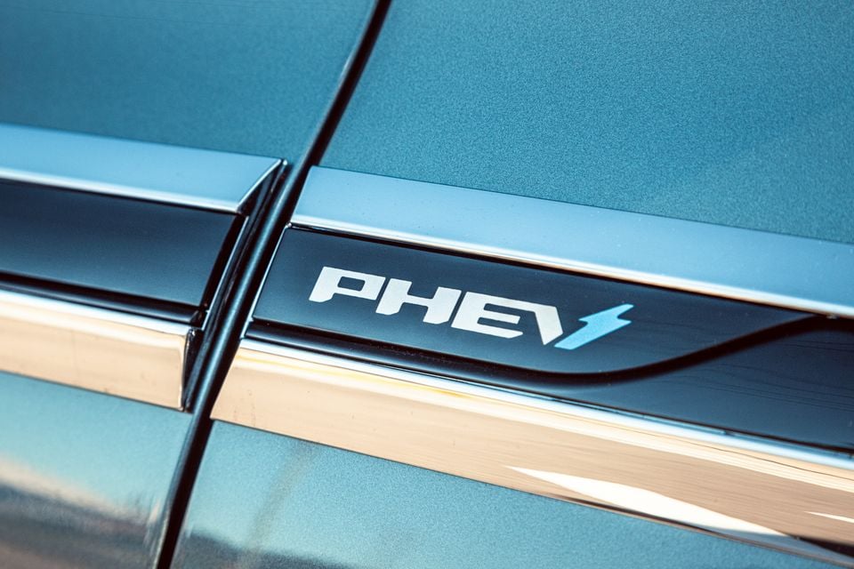 Close-up of a PHEV badge on the side panel of a teal Jaecoo J8 plug-in hybrid